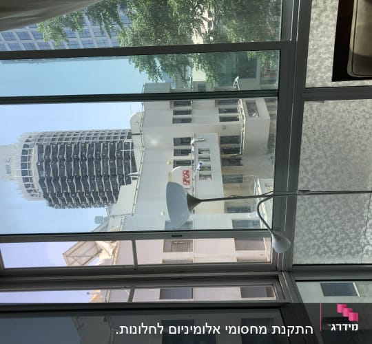 תריסים זכוכית בחלון גדול עם נוף עירוני
